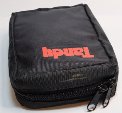 A black zippered fabric pouch with the brand name 'Tandy' printed in red on the front, photographed on a plain white surface.